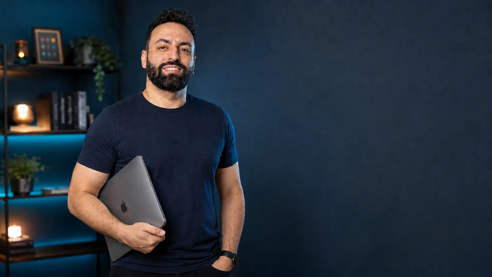 Alessandro Kobs segurando um notebook em seu estúdio